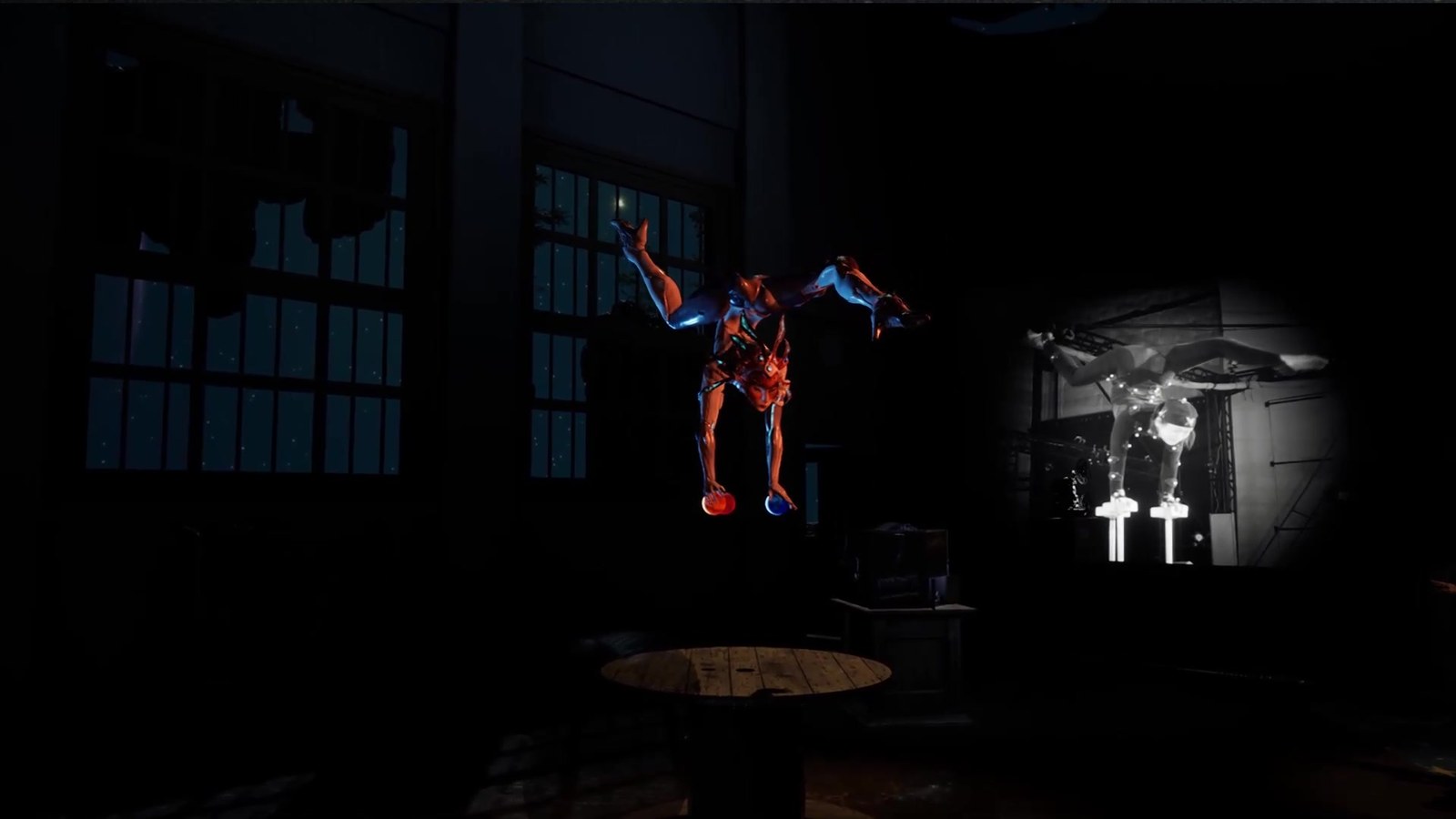 The silver-and-horned character in an inverted handstand balanced on top of the three planet-balls, with the live performer driving the pose visible to the right of frame — a real circus artist in the MoCap volume holding the same handstand on a pair of physical balance balls.