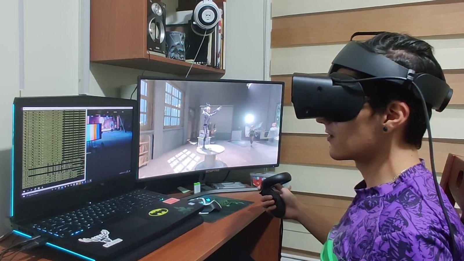 Testing the VR client end-to-end during the build — wearing the Oculus Rift S headset and holding the Touch controller, the live show playing on the desk monitor (silver character on the spool) so I could verify the headset experience against the on-screen render in real time.